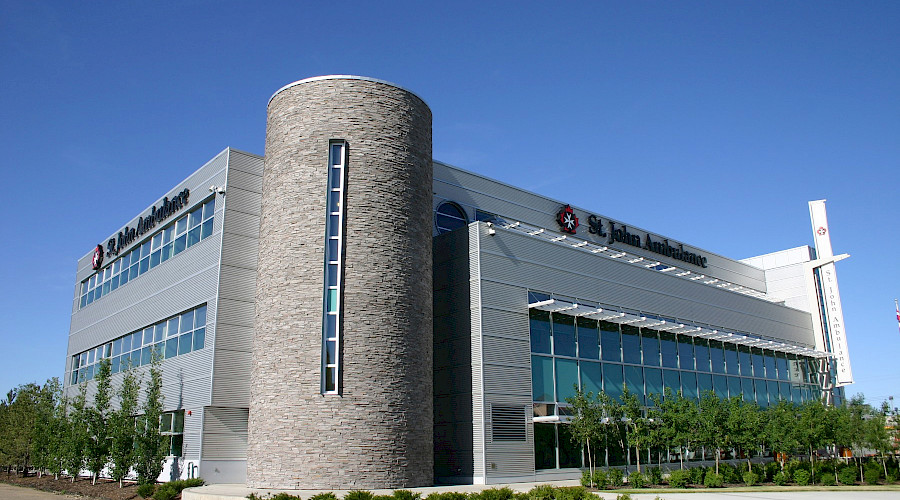 The exterior of the St. John Ambulance building featuring a rounded corner and innovative design.
