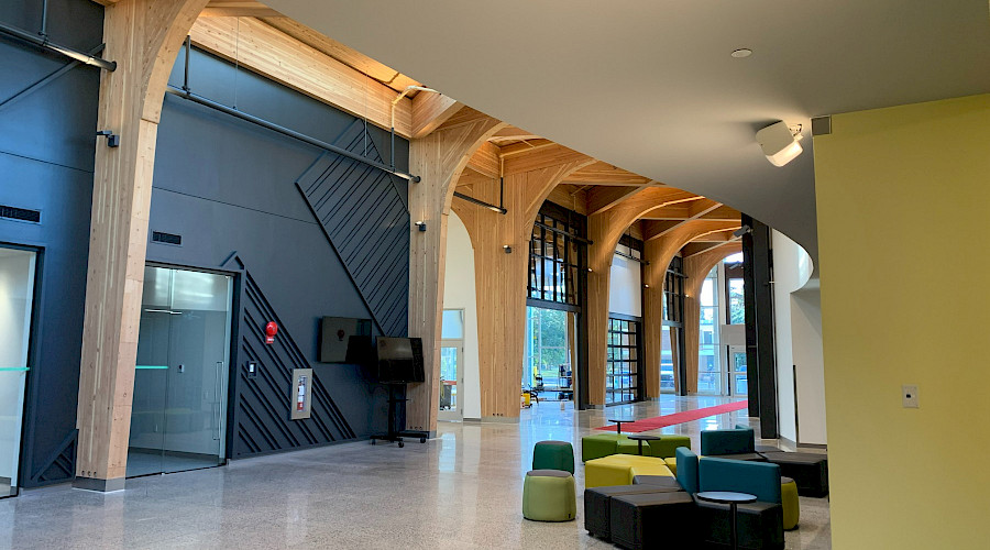 A photo of the interior of the Olds College Learning Hub, featuring it's wood detailing and sleek black walls.