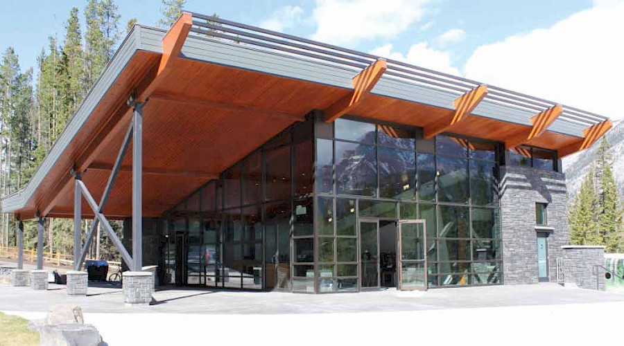 The exterior of the Sulphur Slopes Visitors Pavilion featuring large floor to ceiling windows and a mass timber roof.