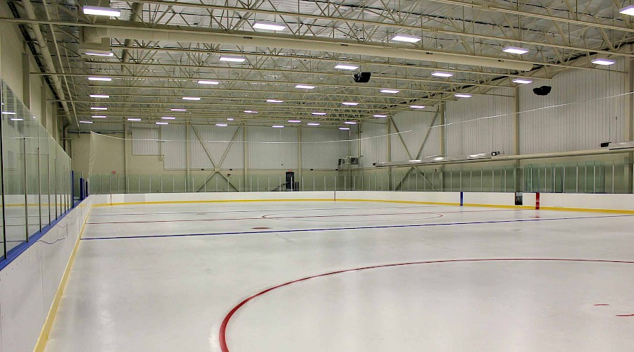 A wide angle shot of the ice in a hockey rink.