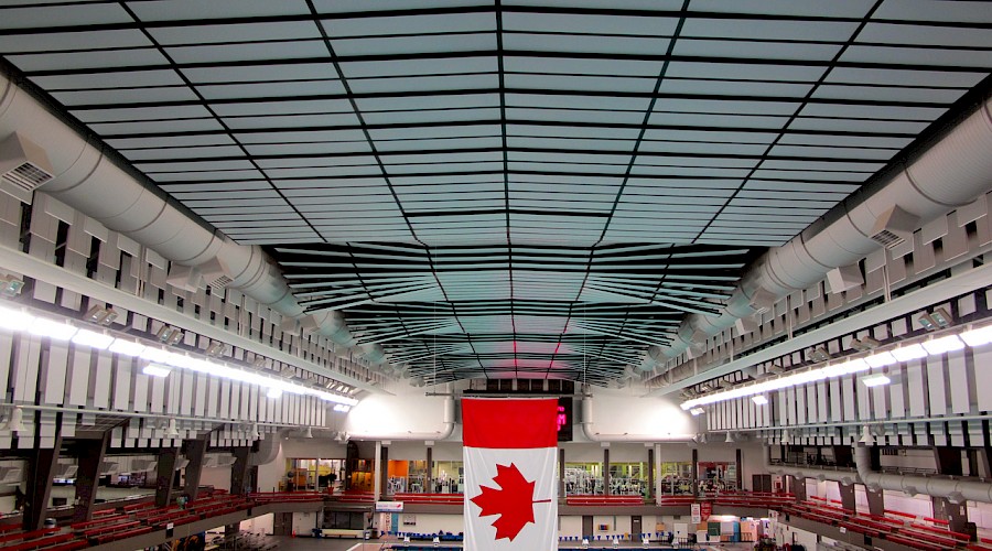 The Canadian flag hanging above a large swimming pool.