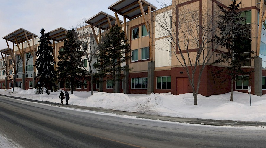 The Villas Caritas Continuing Care Centre behind a road and snow banks.