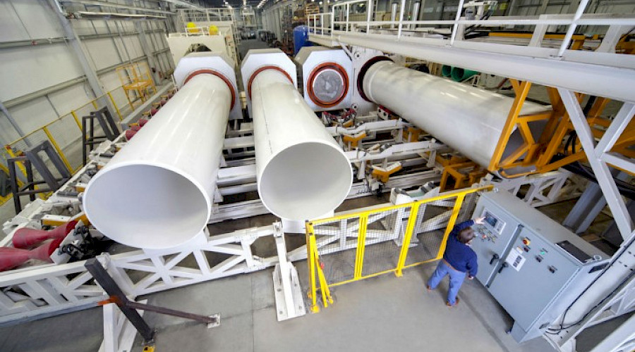 A shot from above of industrial tubes and machinery inside a factory.