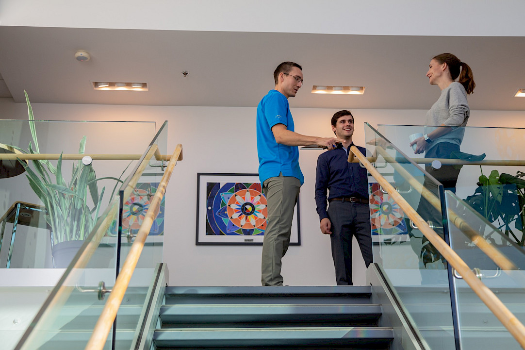 Three Chandos employees chatting in the Edmonton office.