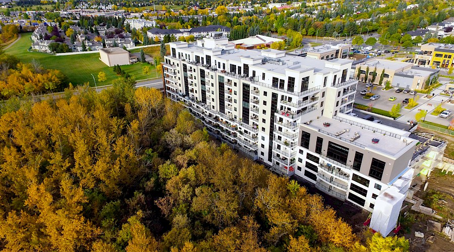 An aerial shot of the Botanica building complex backing onto a forest.