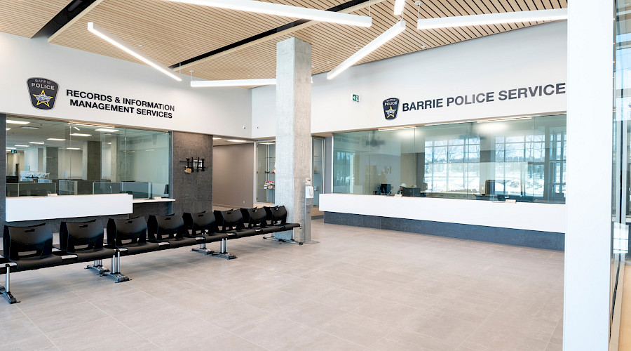 A seating area in the centre of a room with desks behind glass along the walls.