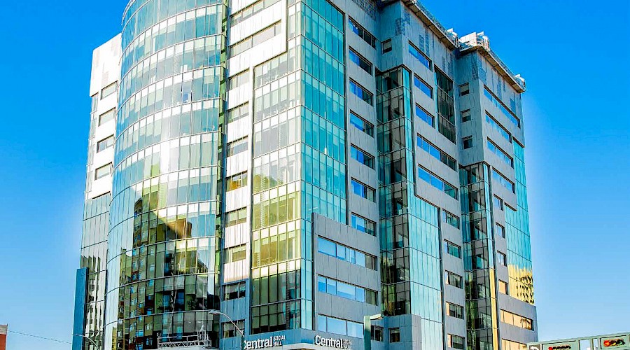 The exterior of the WSP Place building reflecting the sun with a clear blue sky in the background.