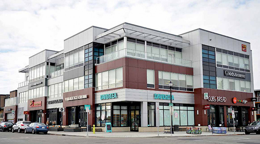 A corner shot of the Garrison Corner building, showcasing the multiple retailers occupying the building.
