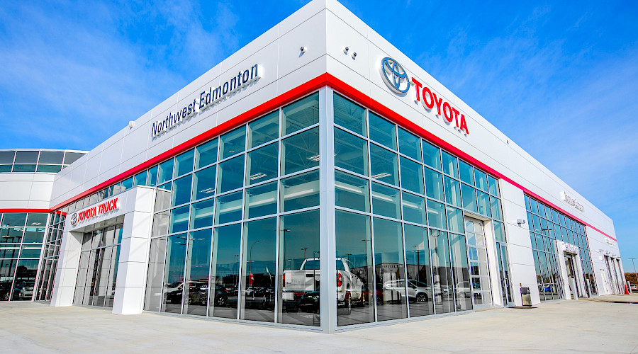 A corner shot of the exterior of the Kingsway Toyota building, with windows displaying the cars and trucks inside.