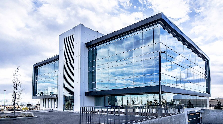 The exterior of the Royal Vista Link building reflecting a cloudy blue sky during the daytime.