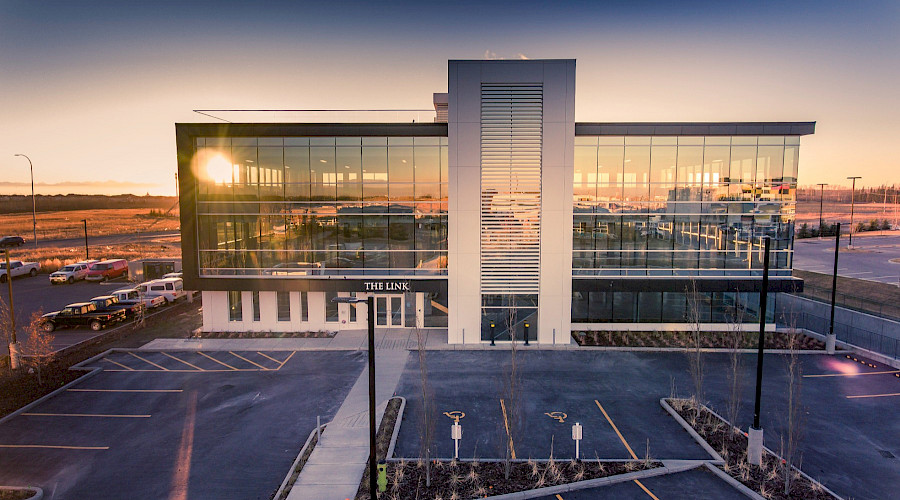 The Royal Vista Link glass building reflecting a sunset.