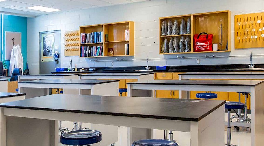 Rows of stools and desks in a classroom.