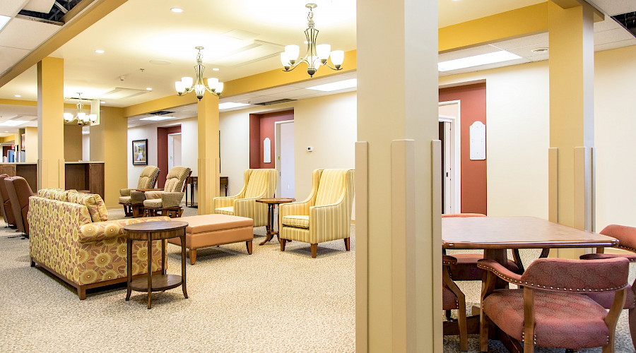 Multiple chairs, sofas and tables in a large common room.