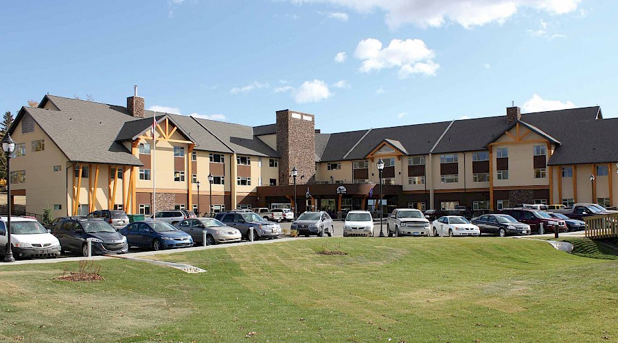 The exterior of the Westview Lodge Care Facility behind a large patch of grass and a parking lot.