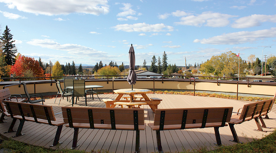 Benches surrounding a table with an umbrella.