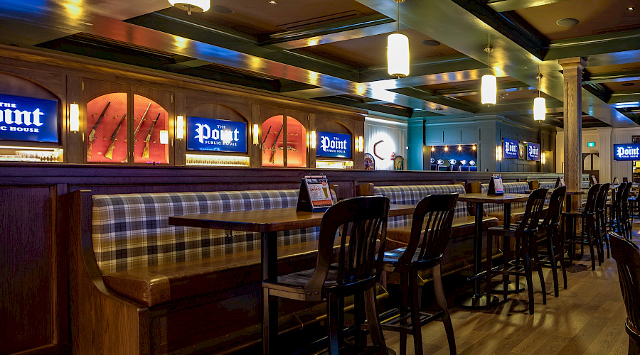 High top tables along a wall with TVs that read 