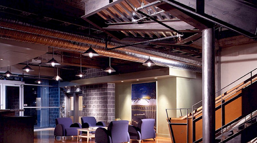 A seating area in a large room with dim light and an exposed ceiling.