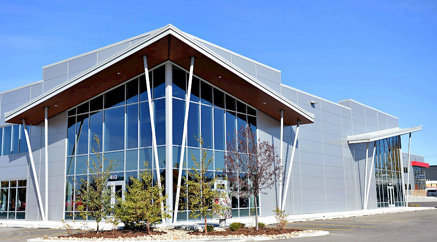 The corner of a building with large windows on a clear day.