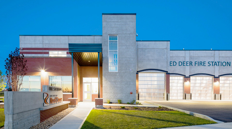 The lit up exterior of the Red Deer Fire Station in the evening.