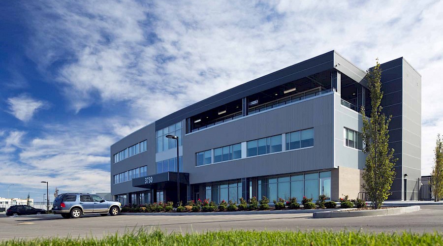 The exterior of the Calgary Police Association building under a cloudy blue sky.