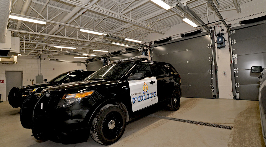 Two police cars parked in a garage.