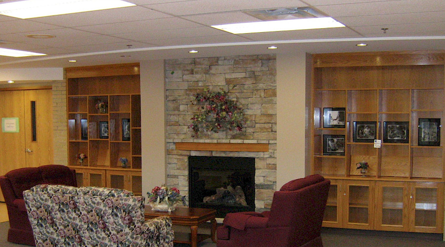 Sofas in a common room in front of a stone fireplace.