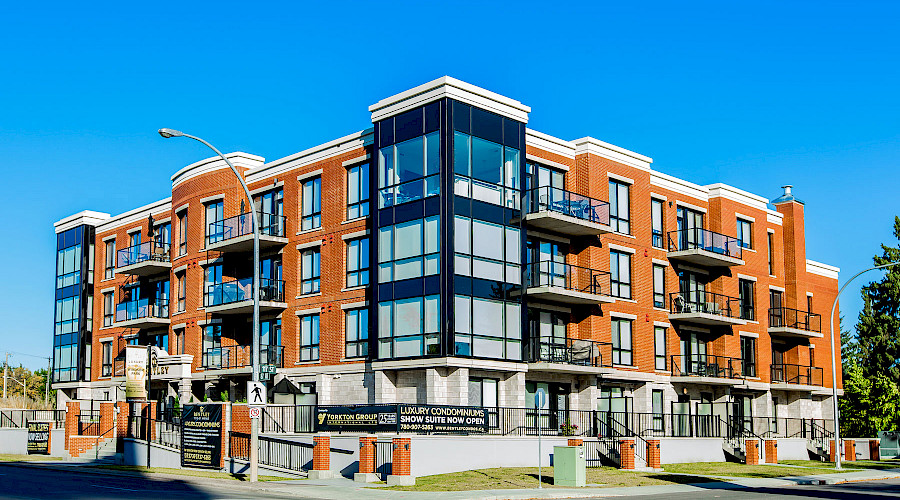 A photo of the brick exterior of the Bentley Condominium featuring it's large corner windows.