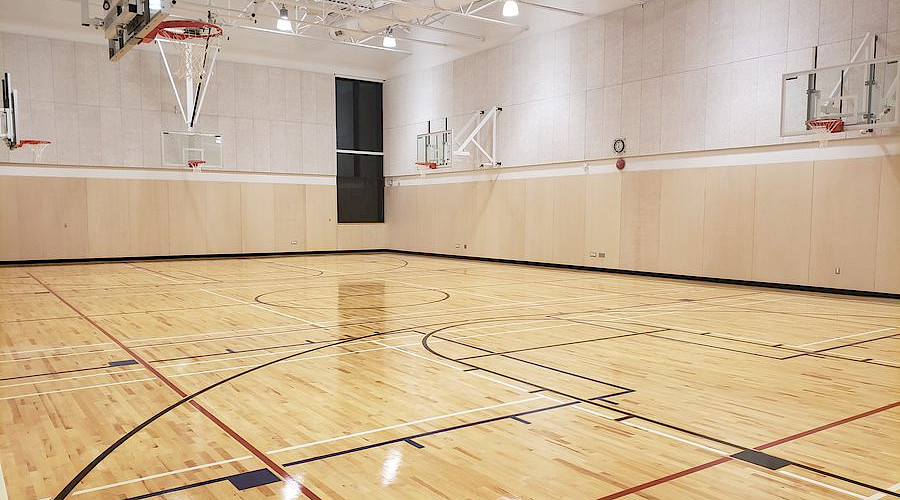 A bright gymnasium with light wood flooring.