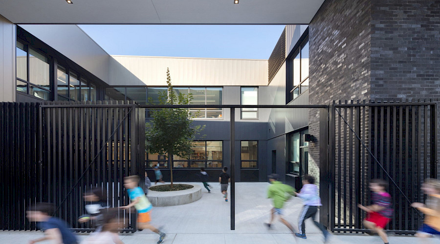 Exterior image of the new Maple Grove School built by Chandos Construction Vancouver, featuring the two-storey school and court yard play area