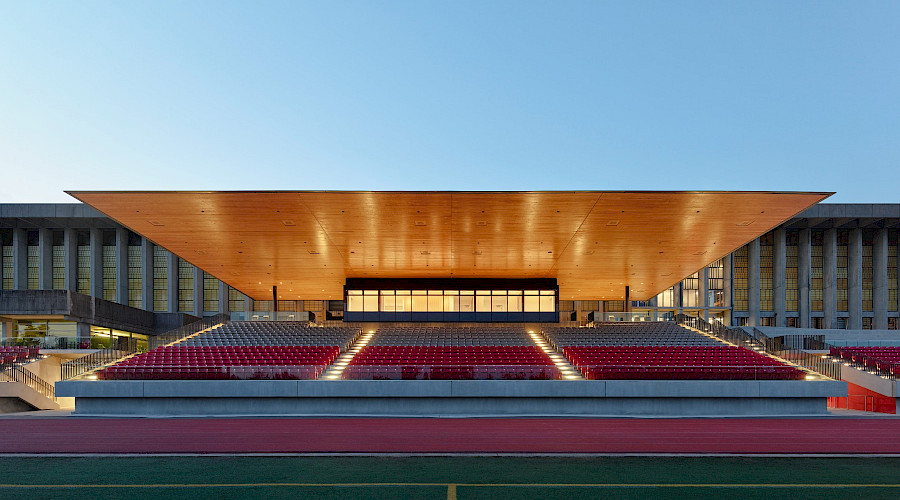 The Simon Fraser University stadium lit up a night highlighting the mass timber roofing.