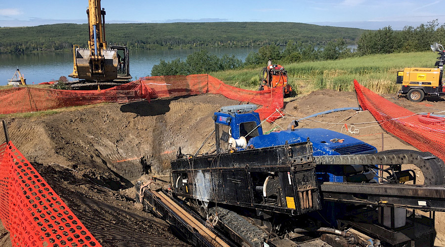 Heavy machinery on a construction site in front of a river.