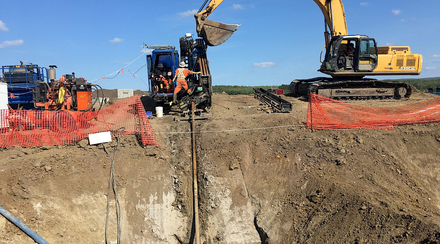 Construction workers using operating heavy machinery on a construction site.