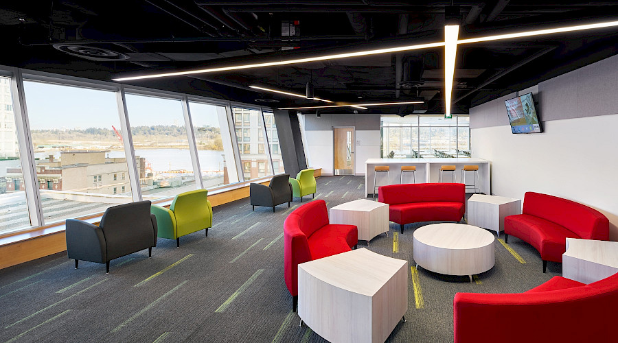 Colourful seating areas in a bright common room with large windows.