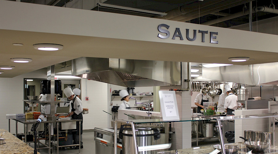 A photo of student chefs working in a busy, moving kitchen.