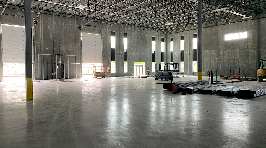 The interior of an open manufacturing facility with concrete walls and flooring.