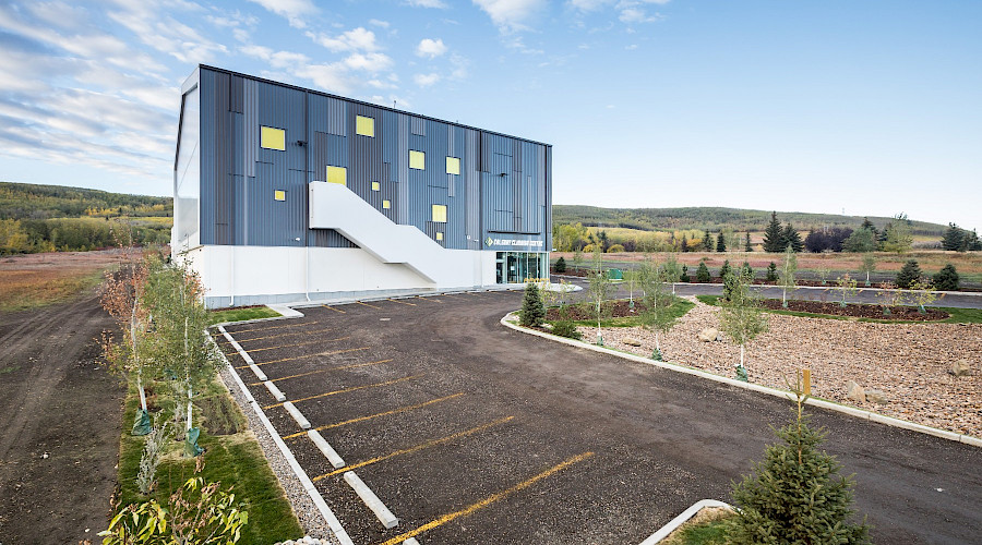 A parking lot in front of the Calgary Climbing Centre in an open landscape.