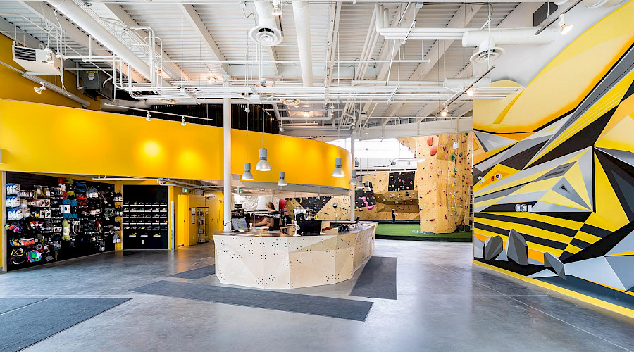 Reception inside the Calgary Climbing Centre with bright yellow and black patterned walls.