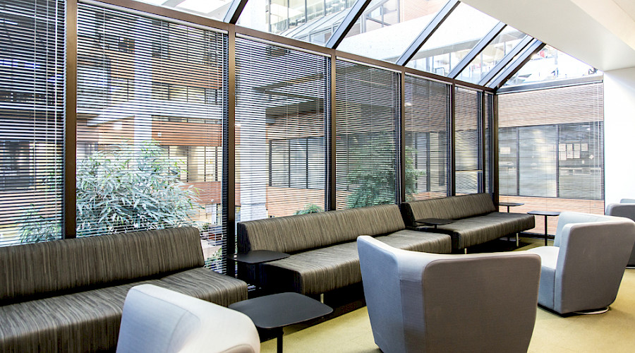 Sofas and chairs in front of windows looking into the centre of a building.