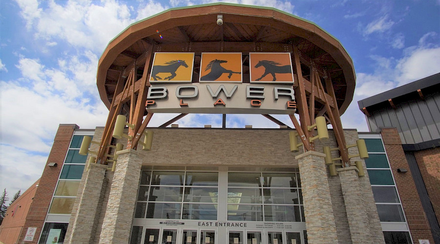 A large sign that reads Bower Place underneath three pictures of horses above the entrance to the mall.