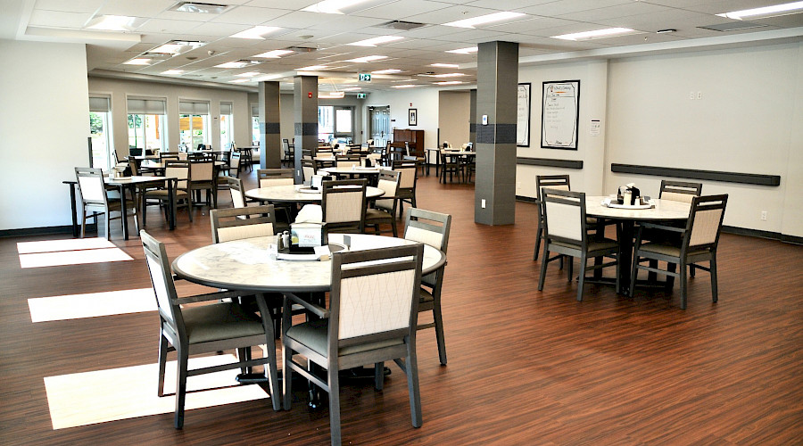 A photo of a dining room with multiple tables and chairs.