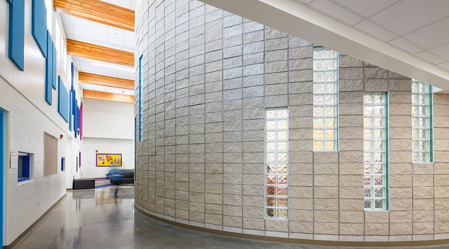 A photo of a rounded off-white stone wall inside Inglewood elementary.
