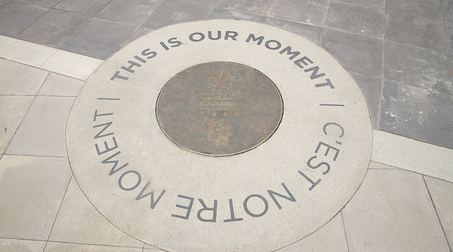 A photo of a monument in the ground that reads 