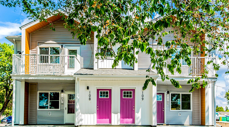 A duplex with two pink front doors directly beside each other.