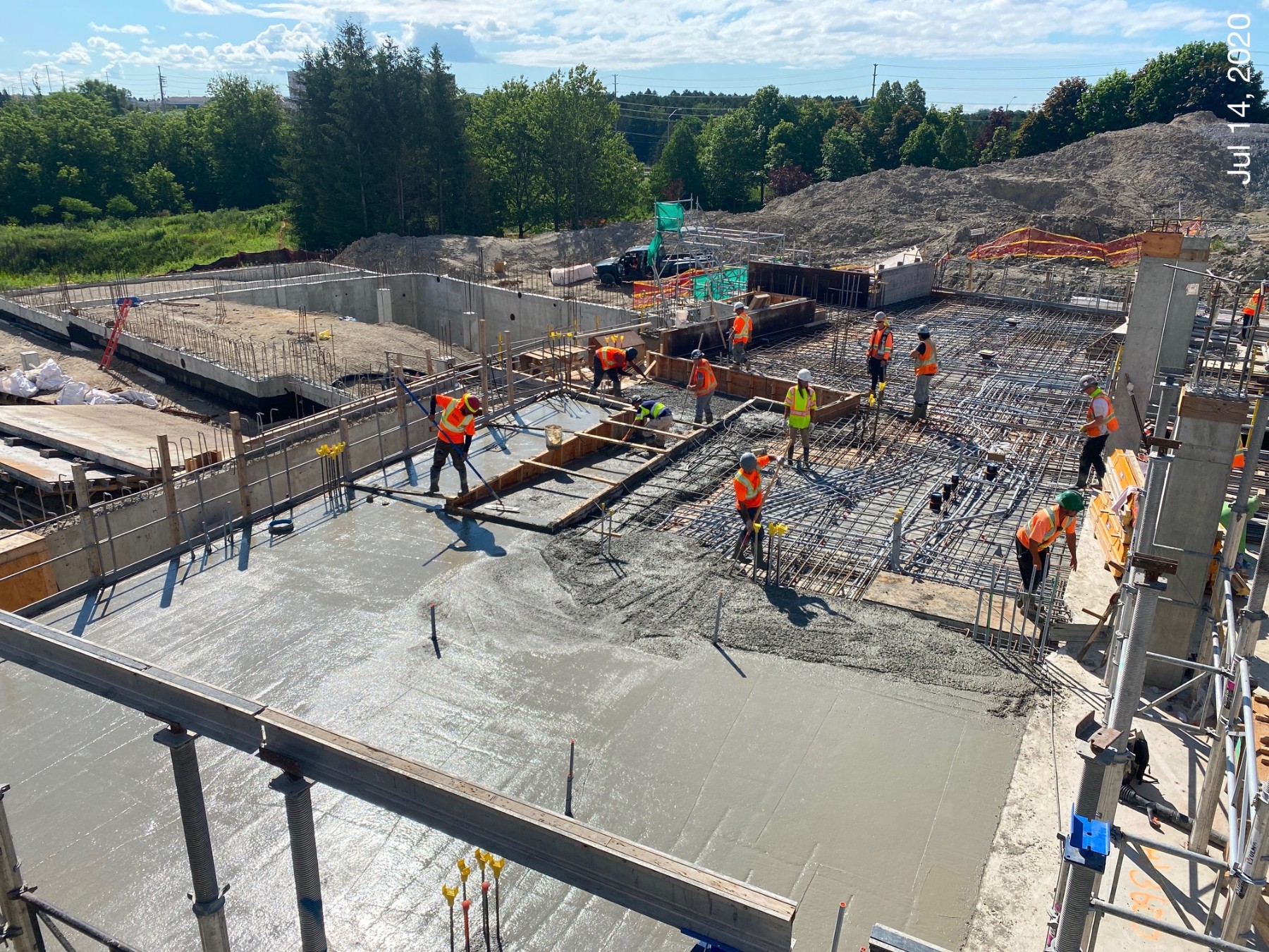 A photo of multiple Chandos construction workers pouring concrete on a large project site.