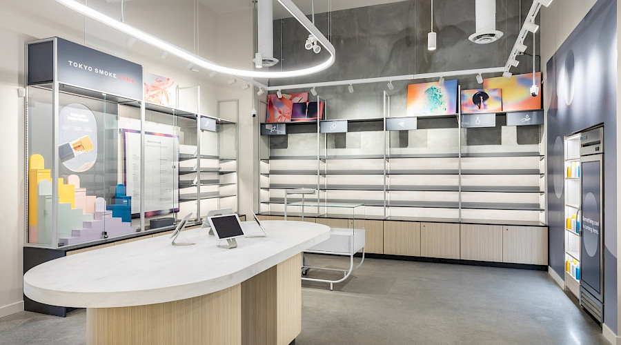 Tablets on an island in a bright room with empty shelves and small colourful art pieces on the wall.