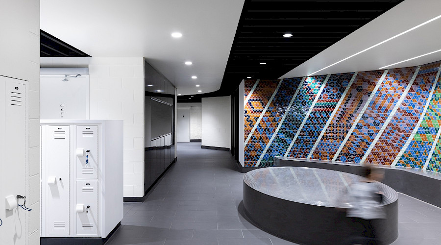 Lockers across from a Mosaic tile wall.