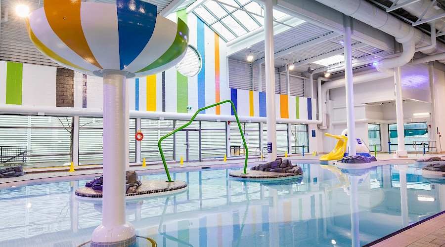 A lazy river in a pool with colourful decorations and walls.