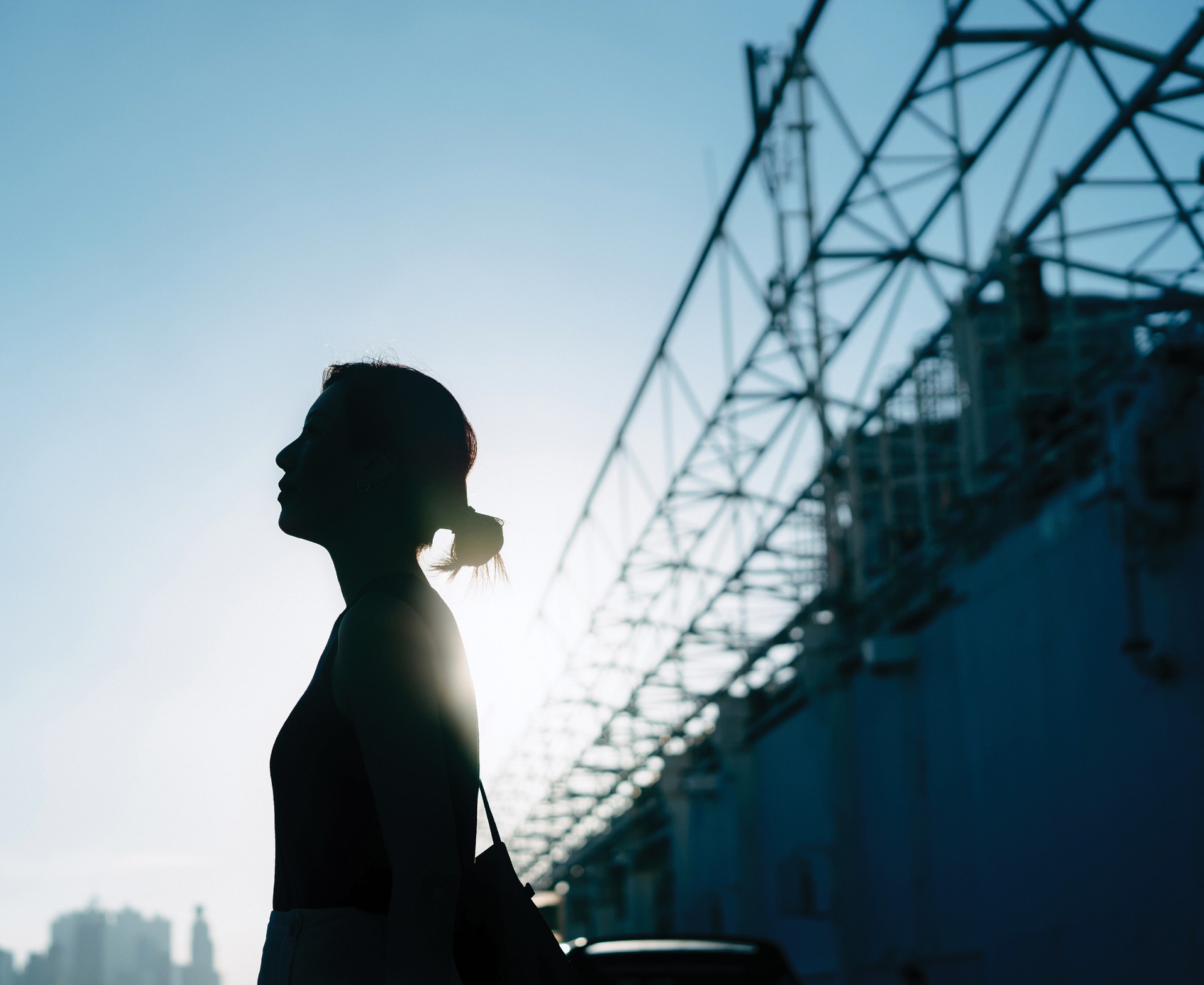 The silhouette of a woman standing in front of a construction project.