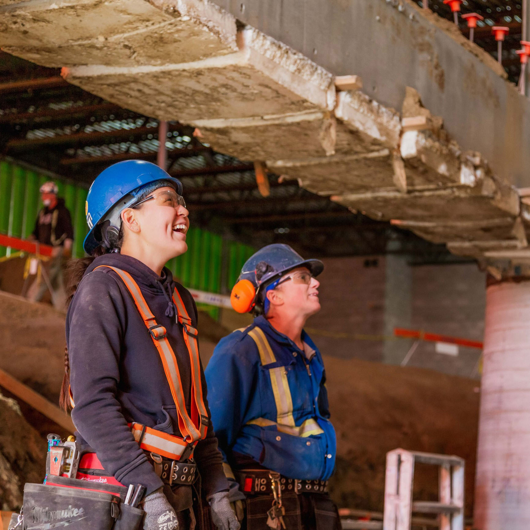 Two female Chandos construction workers participating and laughing in a meeting on site.