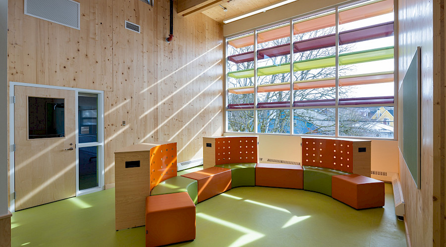 A colourful seating area in a room with light shining in from the windows.